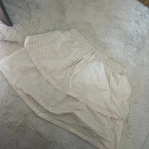 Beige kjol från H&M - Säljer en söt sommrig beige vit randig kjol från H&M!🙌🏼 knappt använd