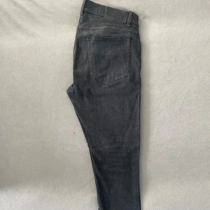 Tiger of Sweden jeans - Snygga svarta jeans från Tiger of Sweden i den eftertraktade slimfit modellen Evolve. De har en klassisk design med fem fickor och en knappgylf. Perfekta för en stilren look. Storlek 31/30 men skulle mer säga 30/30