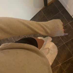 Beige stickad tröja - Säljer en mysig beige stickad tröja med långa ärmar och ribbade muddar. Perfekt för kyligare dagar och enkel att matcha med olika outfits.