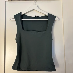 Grön linnetopp från Vero Moda - Säljer en stilren grön linnetopp från Vero Moda. Toppen har en fyrkantig urringning och är ärmlös, vilket gör den perfekt för varmare dagar. Materialet är mjukt och bekvämt. Bara testad 