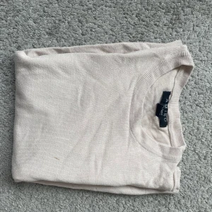 Beige tröja från Amisu - Säljer en stilren beige tröja från Amisu. Tröjan har långa ärmar och en rund halsringning. Perfekt för en enkel och klassisk look. Passar bra till både jeans och kjol. Har en super liten brun fläck på framsidan men inget man tänker på 