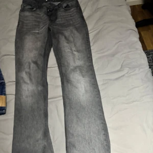 Grå jeansbyxor - Snygga grå jeansbyxor med en klassisk design. De har en rak passform och är perfekta för en avslappnad stil. Byxorna har fem fickor och en knappgylf. Perfekta för dig som gillar en tidlös look.