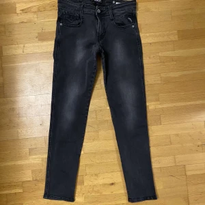 Svarta Replay Anbass jeans - Tjena! Säljer dessa snygga svarta Replay Anbass jeans med wash i storlek 30/32. Jeansen är i väldigt bra skick och har inga defekter. Jag på bilden är runt 175 cm och väger runt 65 kg. Tveka inte att kontakta mig om frågor och bilder!