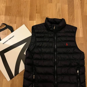Mörkblå dunväst från Polo Ralph Lauren - Ralph Lauren väst i färgen mörkblå |Storlek S men passar även M | Skick 10/10 | Köpt på NK för 3599kr.