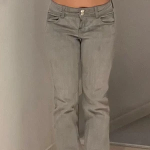 Grå jeansbyxor - Snygga grå jeansbyxor med låg midja och raka ben. Byxorna har två knappar i midjan och praktiska fickor fram. Perfekta för en stilren look. De är från Gina och har lite täcken på användning skriv om du vill ha fler bilder ❤️