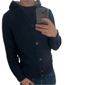 Stickad cardigan - Tja, säljer nu denna feta cardigan från Tommy hilfiger i fint skick. Den har inga defekter eller hål. Modellen på bilden är 185cm lång och cardiganen är i storlek M. Bara att skriva vid eventuella frågor!