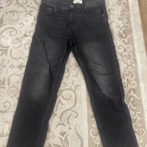 Svarta jeans från Pull&Bear - Snygga svarta jeans från Pull&Bear i en klassisk straight fit. De har en stilren design med fem fickor och knappgylf. Perfekta för en avslappnad look.