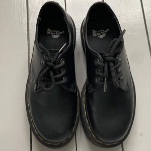 Svarta Dr. Martens skor - Säljer ett par klassiska svarta Dr. Martens skor med snörning och robust sula. Storlek 37 men passar även mig som har 38😊 så snygga och ikoniska. Använda en gång