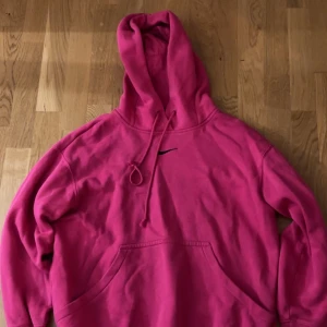 Rosa hoodie från Nike - Säljer en snygg rosa hoodie med matchande byxor från Nike i storlek XS oversized så passar över S kanske också M. Otroligt skön men används inte, har enbart använt den 2 gånger så den är i ny skick! Nypris: 1950kr