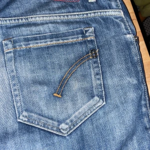 Blå jeans med bakficka - Snygga blå jeans med klassisk femficksdesign och kontrastsömmar. Perfekta för en avslappnad stil. De har en dragkedja och knappstängning.