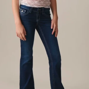 Mörkblå bootcut jeans - Snygga mörkblå bootcut jeans med kontrasterande sömmar. De har en klassisk femficksdesign och en knappgylf. Perfekta för en avslappnad stil.