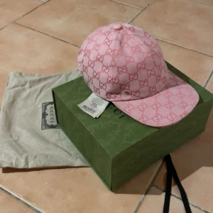  Gucci baseball keps - Snygg rosa keps från Gucci med det ikoniska GG-mönstret🔥. Kepsen är storlek Small men har en justerbar rem baktill och kommer med originalförpackning och dustbag🤩. Perfekt för att ge din outfit en lyxig touch😁… BÄTTRE PRIS VID SNABB AFFÄR!!!