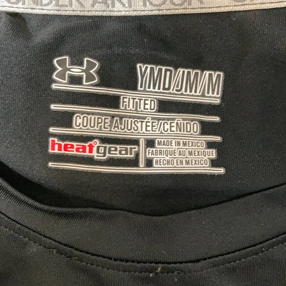Säljer en svart t-shirt från Under Armour med korta ärmar och rund hals. Tillverkad i ett stretchigt material med 90% polyester och 10% elastan. Perfekt för träning med HeatGear-teknologi som håller dig sval och torr. Diskret logga på bröstet och nacken.. T-paidat.