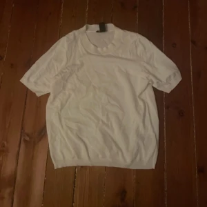 Vit kortärmad tröja - Säljer en enkel och stilren vit tröja med korta ärmar. Tröjan har en rund halsringning och är gjord i ett mjukt material. Skriv för fler bilder!💗