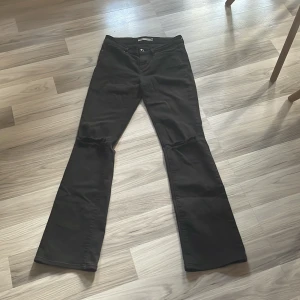 Svarta bootcut jeans - Snygga superlågmidjade svarta bootcut jeans med slitningar på knäna. Säljer då dom är för korta på mig. 26 som står på lappen bak är som S. Jag använder 36 och passar mig bra i midjan.