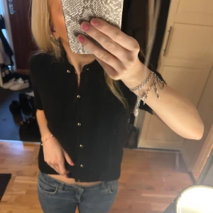 Svart kortärmad kofta med knappar - Super fin stickad topp från Gina. Använd ca två gånger då jag inte tycker den passar mig💕skriv för frågor 