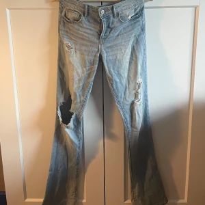 Lågmidjade jeans med hål - Snygga ljusa lågmidjade jeans från Abercrombie & Fitch med slitningar på benen! De är för små för mig och därför jag säljer de🥰så snygga bakfickor och hål