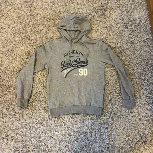 Grå hoodie från Jack & Jones  - Säljer en grå hoodie från Jack & Jones med tryck framtill🔥| Skick 7/10 | Svarar gärna på frågor | Priset är inte hugget i sten |
