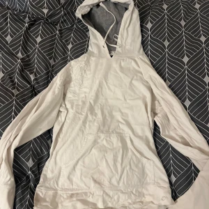 Vit hoodie från Vero Moda - Säljer en vit hoodie från Vero Moda med en snygg broderad detalj på framsidan. Hoodien har en liten fläck längst ner på sidan av tröjan som inte går bort. Den har justerbar huva med snören. Perfekt för en avslappnad stil. Storleken är M men passar även S-xs