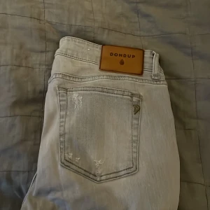 Grå jeans från Dondup - Snygga grå jeans från Dondup med slitna detaljer. Sicker är helt nytt// 10/10🌟 jeansen sitter slim och str 31 i midjan🌟priset är inte hugget i sten men jätte bra pris för sicket🤍🤍