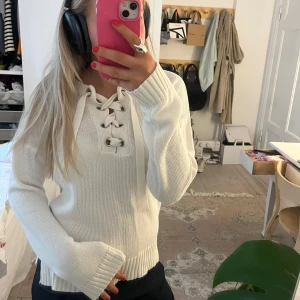 Vit stickad tröja med snörning - Säljer en vit stickad tröja med snörning framtill. 
