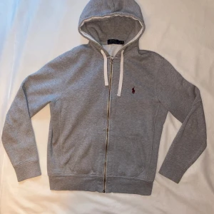 Ralph Lauren Polo Grå Hoodie - Ralph Lauren Polo Gray Hoodie – Size M Stylish and comfortable hoodie from Ralph Lauren Polo in gray. Perfect for casual days or as a layer in your outfit! Size: M (Fits well for S/M) Color: Gray Condition: 7/10 – Slightly used, but in good condition! Brand: Ralph Lauren Polo – quality garments that last. Why you’ll like it: * Timeless design that goes with anything. * Super soft and comfortable. * A classic hoodie that never goes out of style. Feel free to ask if you want more pictures!