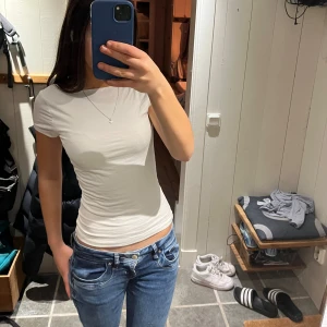 Vit kortärmad topp med öppen rygg från gina tricot - Säljer somrig vit t shirt från gina med öppen rygg. Använd fåtal gånger och är i ett väldigt bra skick! Jättefin på sommar och skönt med öppen rygg! Säljer för den inte kommit till användning❤️