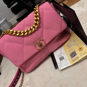 Rosa quiltad axelväska med guldkedja - Snygg rosa axelväska i tyg. Medkommer med påse och papper, köpt från en annan person på plick, men behöver rensa väskor så denna får säljas vidare. Jättefint skick som rymmer extremt mycket. 
