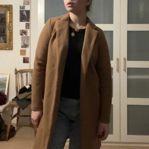Brun kappa från Zara - Snygg brun kappa från Zara i en klassisk design. Perfekt för höst och vinter med sin långa ärm och stilrena look. Tillverkad i ett mjukt material som ger en bekväm passform.