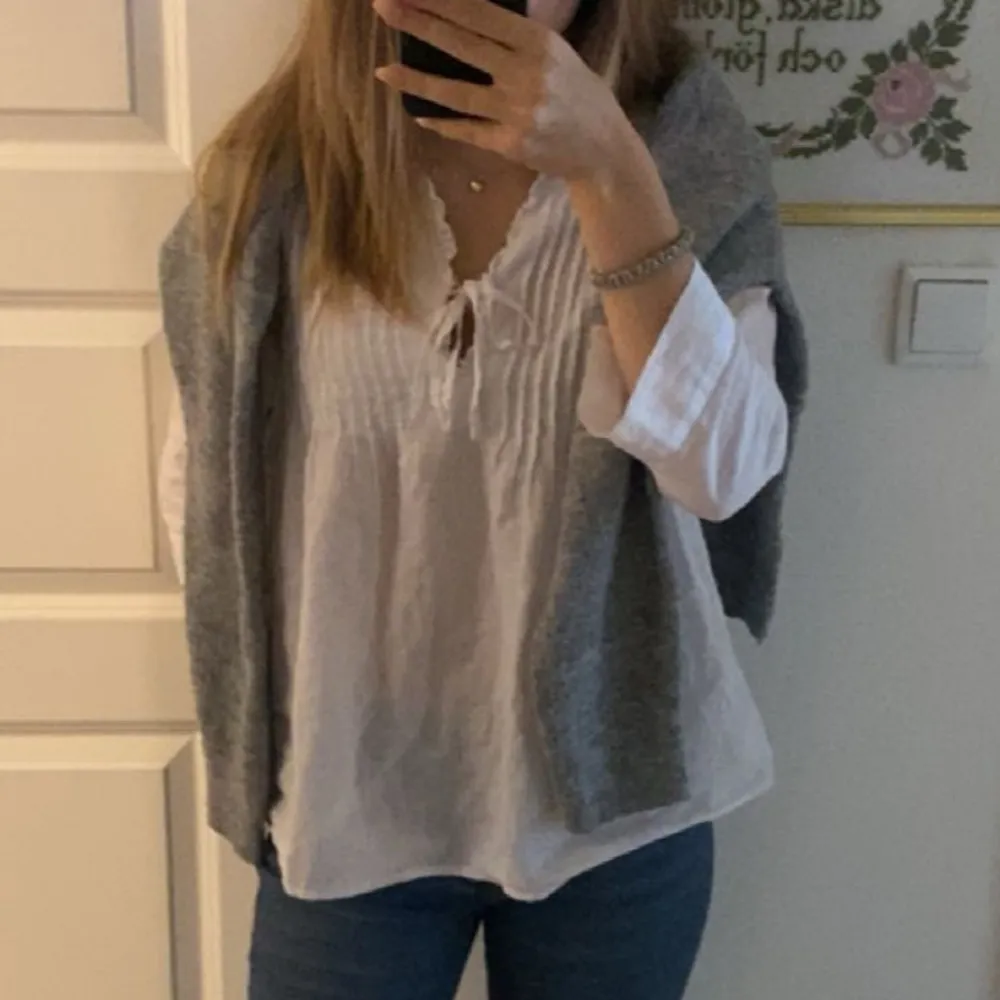 Säljer en luftig vit blus med knytning framtill och trekvarts ärmar. Perfekt för en avslappnad stil. Blusen har en fin struktur och är lätt att matcha med olika outfits.. Puserot.