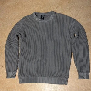 Grå  tröja  - Snygg grå ribbad tröja  med rund halsringning. Perfekt för kyligare dagar med sin stilrena design och bekväma passform. Ett måste i garderoben för en klassisk look.