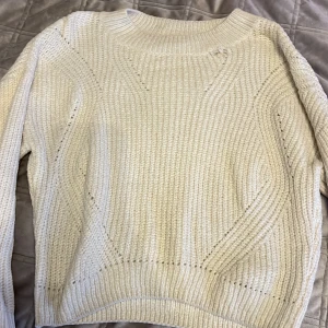 Vit stickad tröja från H&M - Säljer en mysig vit stickad tröja från H&M. Tröjan har ett enkelt och stilrent mönster med långa ärmar och rund halsringning. Perfekt för kyliga dagar. Passar bra till både jeans och kjol. 🧶den har en lite defekt som jag visar på bilden men den är i ok skick. 