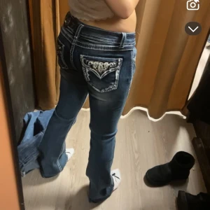Blå jeans med broderade fickor - Säljer ett par snygga blå jeans med unika broderade detaljer på bakfickorna. De har en bootcut-stil och är perfekta för både vardag och fest. Jeansen är i bra skick och har en normal passform. Kan tänka mig att gå ner i pris  Nypris 1500