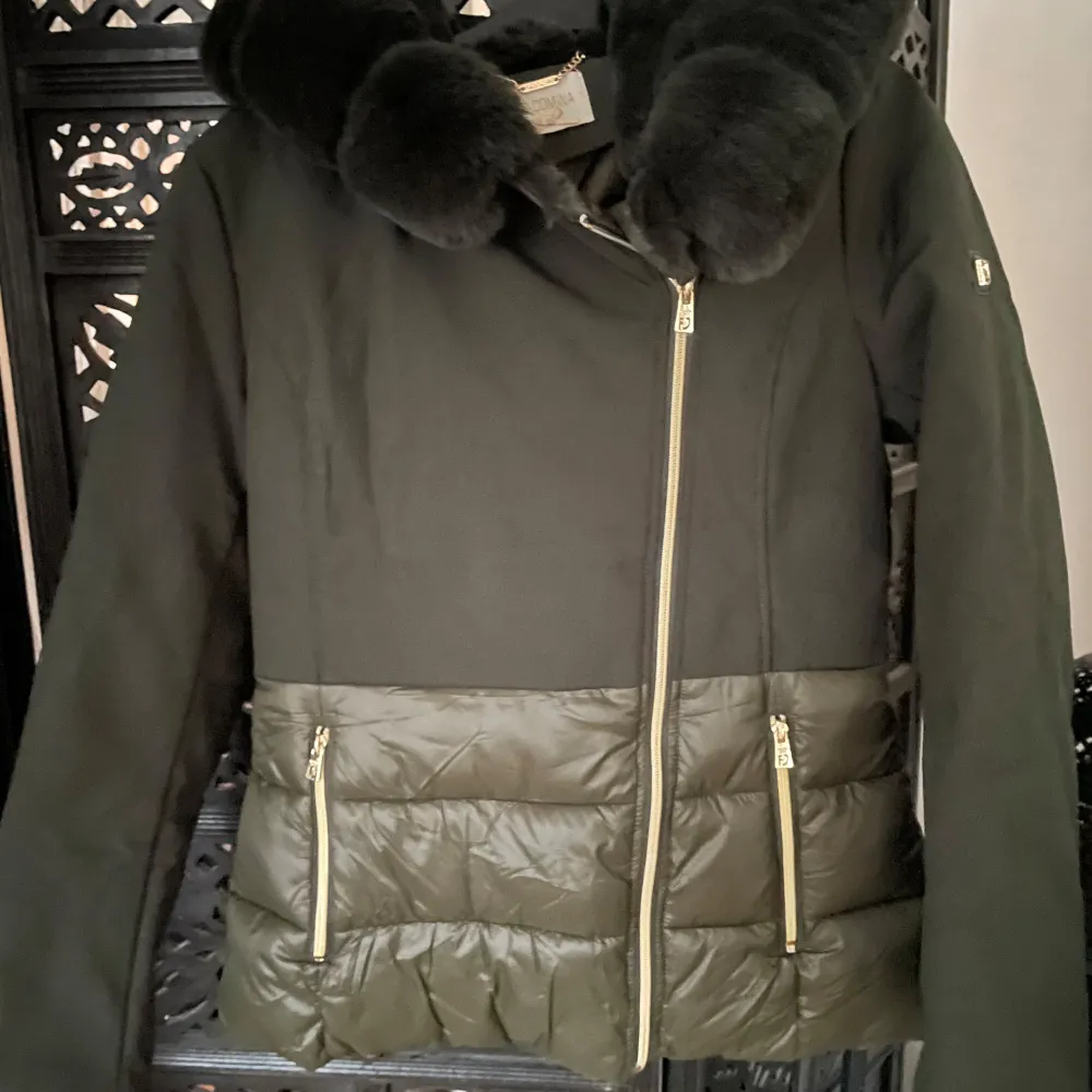 Säljer en snygg svart vinterjacka från Fracomina med pälskrage och dragkedja. Jackan har två praktiska fickor med dragkedjor och en quiltad design på nedre delen. Perfekt för kalla vinterdagar!. Takit.