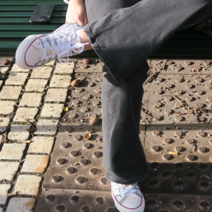 Randiga sneakers i vitt och blått - Säljer ett par snygga sneakers med vit bas och blå ränder. De har klassisk snörning och en röd rand längs sulan. Perfekta för en avslappnad stil och passar till både jeans och shorts. Använd dem för en cool och bekväm look!