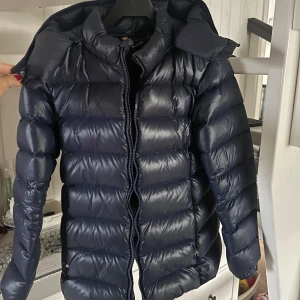 Mörkblå dunjacka från Polo Ralph Lauren - Säljer en snygg marinblå dunjacka från Polo Ralph Lauren i storlek XL i BARNSTORLEK, så i vanlig storlek är den som en S/XS, jag brukar ha S i kläder. Använd 2 vintrar knappt men är som ny 