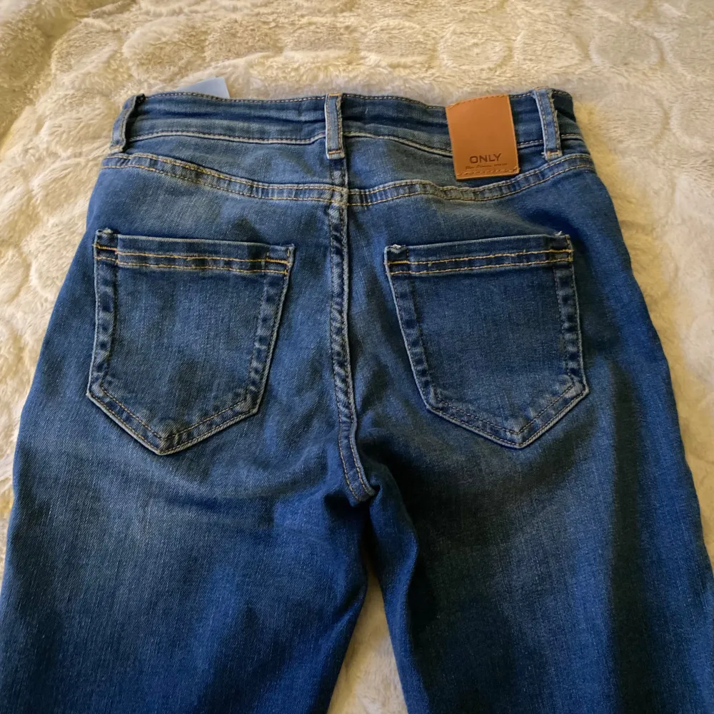 Säljer ett par snygga blå jeans från ONLY i storlek XS. De är i mycket bra skick och använda fåtal gånger. Midjan är 35 cm men stetchigt material.💕. Jeans & Byxor.