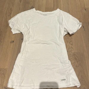 Vit t-shirt från 157 - Säljer en enkel och stilren vit t-shirt från 157. Den är i bomull och har en normal passform med korta ärmar. Perfekt för vardagsbruk eller som basplagg i garderoben. Skicket är bra och den är superbekväm att ha på sig!