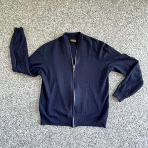 Mörkblå kofta från Stenströms - Säljer en stilren mörkblå kofta från Stenströms i mycket bra skick. Den har en praktisk dragkedja framtill och ribbade kanter vid hals och ärmslut. Perfekt för både höst och vår, och funkar lika bra till vardags som till lite finare tillfällen. Nypris 2300kr