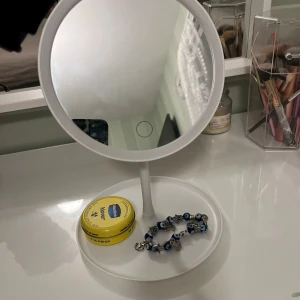 Vit spegel med belysning  - Säljer en snygg vit spegel med belysning perfekt för när man ska sminka sig! Köpt ganska nyligen 