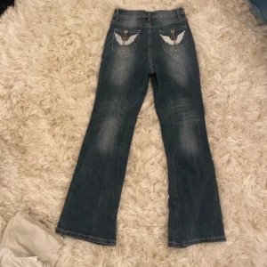 Jeans - Säljer ett par coola jeans med broderade vingar på bakfickorna. Knappt använd🩷