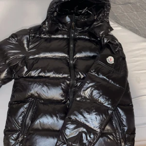 Svart Moncler maya  - Säljer en snygg svart pufferjacka från Moncler. Den är i mycket bra skick har används 2-3 gånger och är perfekt för vintern. Jag säljer den eftersom att den är lite för stor för mig den är i storlek 2 som passar M. Har inget kvitto eller låda. NFC-scan och QR coden fungerar.