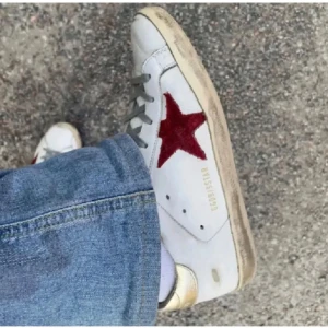 Golden Goose Superstar sneakers - Säljer ett par vita sneakers från Golden Goose i modellen superstar med en cool röd stjärna på sidan o guldiga detaljer. Box, dustbag och lapparna följer med. Köpta i London. Kan även mötas upp💕💕