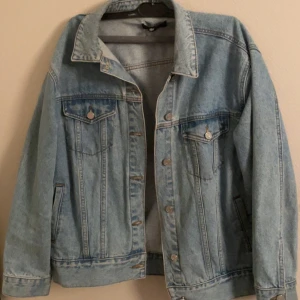 Ljusblå jeansjacka - Säljer en klassisk ljusblå jeansjacka i normal passform. Jackan har långa ärmar och knappar framtill samt på bröstfickorna. Perfekt för vår och sommar! 🧢
