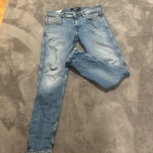 Blå jeans från Replay - Säljer ett par snygga blå jeans från Replay, modell Anbass. De har en klassisk femficksdesign och är i bra skick. Perfekta för både vardag och fest! 🕺