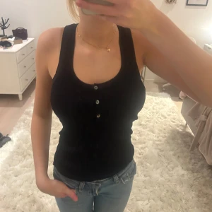 Marinblått linne - Marinblått ribbat linne med knappar!  är i ett mjukt och stretchigt material som sitter skönt mot kroppen. Passar både till vardags och fest! 🖤