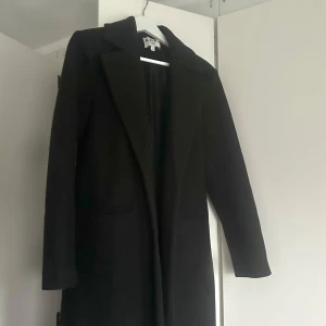 Svart lång kappa - Superskön och fin lång svart kappa, använd en gång och i ett jättebra och starkt material. Perfekt som höstjacka. Har två fickor och är i storlek 34. Passar xs och s skulle jag säga.🖤🍂