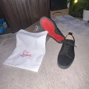 Säljer ett par svarta sneakers från Christian Louboutin i mycket bra skick. Skorna har den ikoniska röda sulan och är gjorda i skinn. Perfekta för både vardag och fest! Kommer med originalpåse.