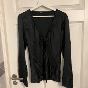 Silke blus med knyt från Zara - En jättefin silkes blus från Zara som man kan byta i fram i storlek XL i djup V-ringning . Liten i storlek och är bara använd 1 gång