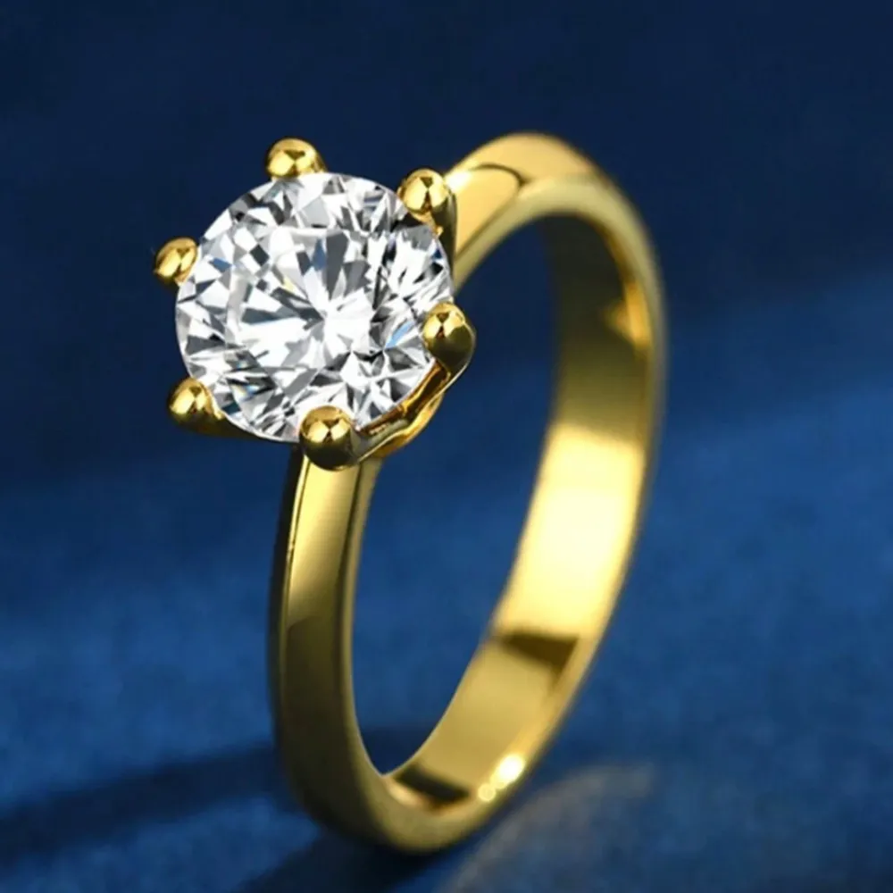 Säljer en elegant guldfärgad  ring med Moissanite  klar sten i mitten. Perfekt för speciella tillfällen eller som en vacker accessoar till vardags. Ringen har en klassisk design med sex klor som håller stenen på plats. Passar perfekt för dig som vill ha något stilrent och tidlöst. . Accessoarer.